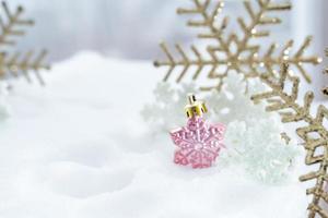 noël d'hiver - boules de noël avec ruban sur la neige, concept de vacances d'hiver. boules de noël rouges, boules dorées, décorations de pins et de flocons de neige sur fond de neige photo