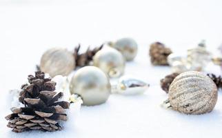 noël d'hiver - boules de noël avec ruban sur la neige, concept de vacances d'hiver. boules de noël rouges, boules dorées, décorations de pins et de flocons de neige sur fond de neige photo