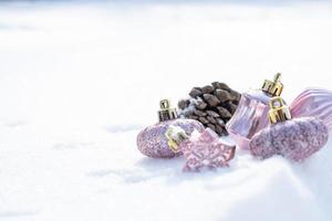 noël d'hiver - boules de noël avec ruban sur la neige, concept de vacances d'hiver. boules de noël rouges, boules dorées, décorations de pins et de flocons de neige sur fond de neige photo