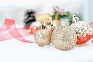 noël d'hiver - boules de noël avec ruban sur la neige, concept de vacances d'hiver. boules de noël rouges, boules dorées, décorations de pins et de flocons de neige sur fond de neige photo