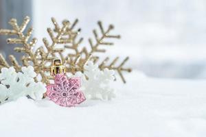 noël d'hiver - flocons de neige de noël sur la neige, concept de vacances d'hiver. décorations de flocons de neige blancs et dorés sur fond de neige photo