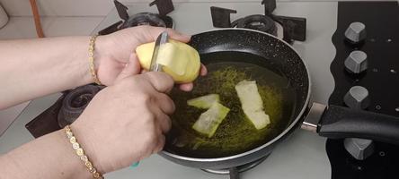 épluchures de pommes de terre dans l'huile pour la fabrication de croustilles, croustilles aalu photo