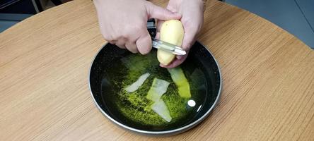 épluchures de pommes de terre dans l'huile pour la fabrication de croustilles, croustilles aalu photo