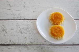 gâteaux de fil de jaune d'oeuf d'or dans une assiette blanche sur une table en bois. photo