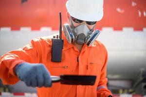 un homme travaillant dans un champ pétrolifère ou une plate-forme pétrolière et il vérifie ou inspecte le pétrole. photo