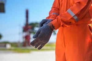 portant des gants de sécurité de construction photo gros plan. homme portant des gants de sécurité sur le site du champ pétrolifère