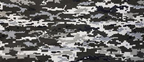 tissu avec une texture de camouflage pixélisé militaire ukrainien. tissu avec motif camouflage en formes de pixels gris, marron et vert. uniforme officiel des soldats ukrainiens photo