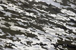 tissu avec une texture de camouflage pixélisé militaire ukrainien. tissu avec motif camouflage en formes de pixels gris, marron et vert. uniforme officiel des soldats ukrainiens photo