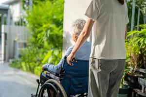 soignant aide et soins asiatique senior ou âgée vieille dame patiente assise sur un fauteuil roulant jusqu'à la rampe dans l'hôpital de soins infirmiers, concept médical fort et sain. photo