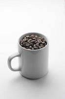 grains de café bio torréfiés dans une tasse blanche photo