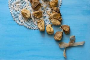 tas de figues séchées sur une serviette tricotée sur une table bleue. fruit sec. photo