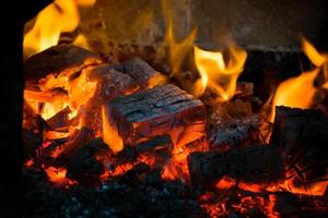 crête de flamme sur bois brûlant dans la cheminée. brûler du bois de chauffage dans un poêle russe. photo