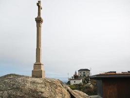 croix et vue sur le phare du cap finisterre photo