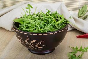 Roquette dans un bol sur fond de bois photo