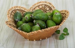 Feijoa dans un panier sur fond de bois photo