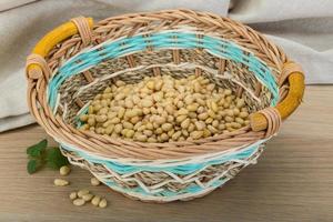 Noix de cèdre dans un panier sur fond de bois photo