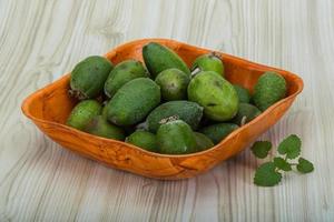 Feijoa dans un bol sur fond de bois photo