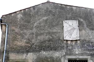 mur de maison médiévale avec horloge solaire photo