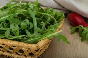 Roquette dans un panier sur fond de bois photo