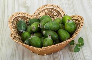 Feijoa dans un panier sur fond de bois photo