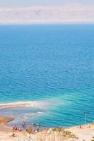 gens sur la plage de sable de la mer morte photo