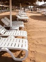 transats vides sur la plage de la ville d'aqaba en hiver photo