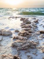 sel cristallin sur la côte de la mer morte au coucher du soleil photo