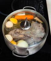 bouillir du bouillon de boeuf avec des légumes d'assaisonnement photo