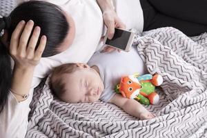 maman travaille au téléphone quand le bébé dort à proximité. photo