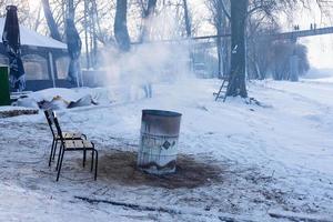 feu dans un tonneau par temps froid d'hiver. les réfugiés, les immigrés illégaux, les sans-abri brûlent un feu de baril pour se réchauffer. photo
