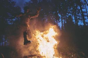 soldat en action la nuit sautant par-dessus le feu photo