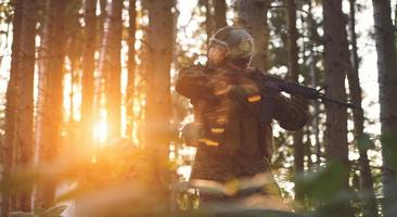 Soldat en action visant l'optique de visée laser de l'arme photo