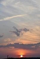 beaux nuages de ciel d'été au coucher du soleil et un avion volant. coucher de soleil ciel du soir le soir. photo