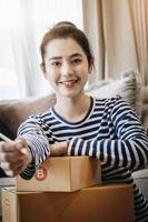 idée d'entreprise de vente en ligne, belle fille souriant joyeusement de la vente de produits en ligne à domicile. photo