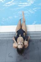 joyeuse jeune femme caucasienne en maillot de bain profite de la journée au centre de spa, tout en faisant la sieste entre les séances de sauna et de piscine. photo