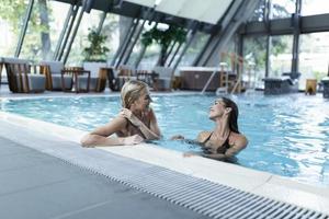 portrait de deux belles femmes se relaxant dans la piscine du spa photo