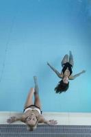 photo de recul de deux jeunes femmes se relaxant dans la piscine d'un spa