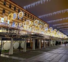 la rue de la ville est décorée pour les vacances de noël et du nouvel an. lumières apparentées dans la rue photo