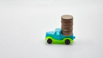 pièces d'argent empilées sur un camion bleu-vert. concept de fond blanc police d'assurance automobile affaires financières photo