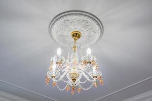 lustre à la mode dans un intérieur lumineux suspendu sous le plafond d'un palais, d'un appartement ou d'un hôtel photo