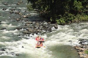 photo d'activités de rafting réalisées par un groupe de personnes sur une rivière rocheuse à fort courant