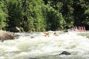 photo d'activités de rafting réalisées par un groupe de personnes sur une rivière rocheuse à fort courant