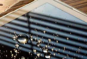 eau renversée sur la tablette, gouttes d'eau sur l'écran de la tablette photo