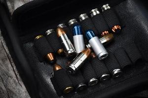 Balles de pistolet de 9 mm conservées dans une poche en cuir noir, mise au point sélective sur la balle. photo