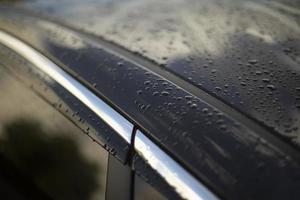 surface humide de la voiture. gouttes sur la voiture noire. détails des transports. photo
