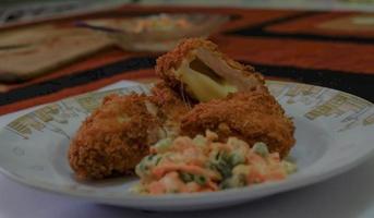 c'est de la cuisine maison, le poulet cordon bleu ou schnitzel cordon bleu est un plat de viande de poulet enveloppé dans du fromage, puis pané et frit. photo