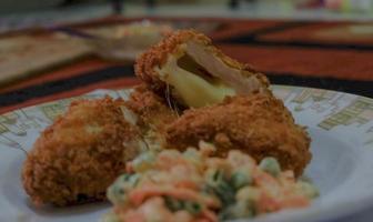 c'est de la cuisine maison, le poulet cordon bleu ou schnitzel cordon bleu est un plat de viande de poulet enveloppé dans du fromage, puis pané et frit. photo