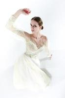 modèle de jeune fille dans un studio photo dans une robe de mariée gestes avec ses mains posant sous un angle supérieur