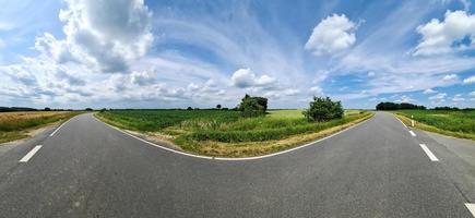 beau panorama haute résolution d'une route de campagne du nord de l'europe avec des champs et de l'herbe verte. photo