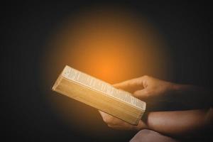 main de jeune femme tenant la sainte bible avec étude à la maison. livre de lecture chrétienne femelle adulte à l'église. fille apprenant la spiritualité religieuse avec prier Dieu. concept de foi en éducation des étudiants. photo